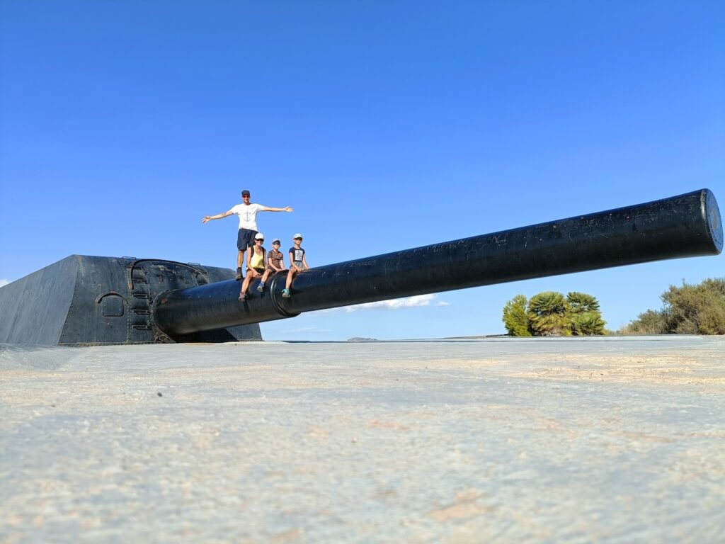Famille debout sur un énorme canon 2eme guerre mondiale