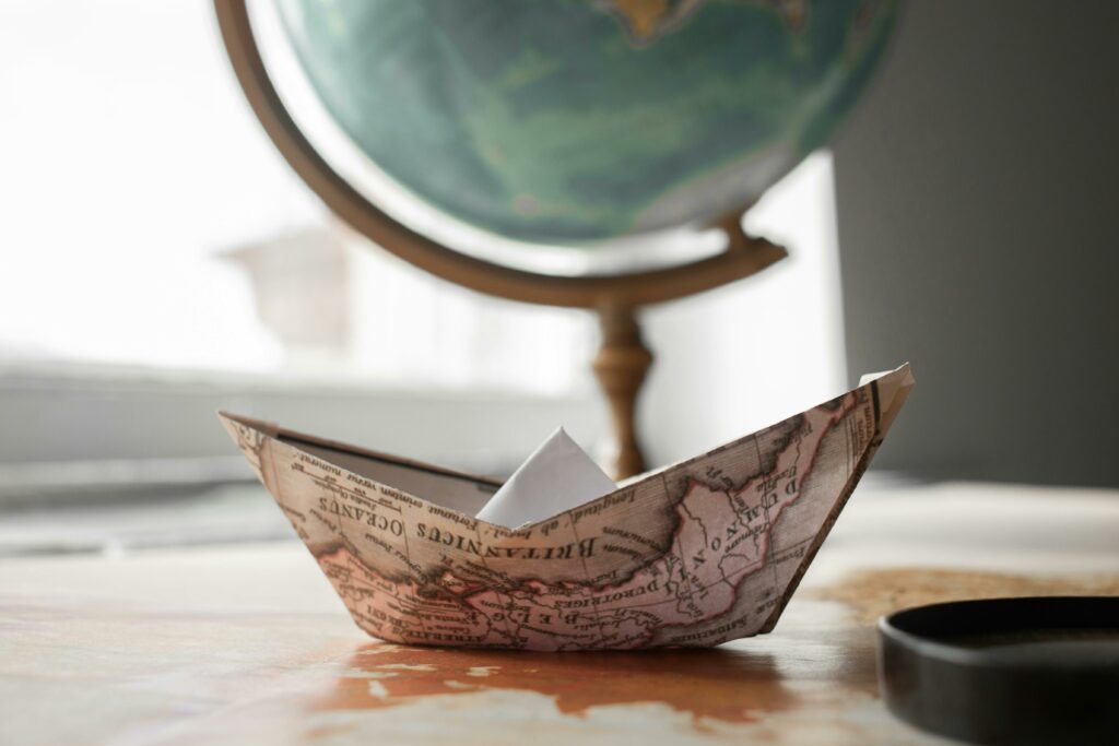 bateau en papier fait avec une carte du monde, symbolisant le voyage avec les enfants