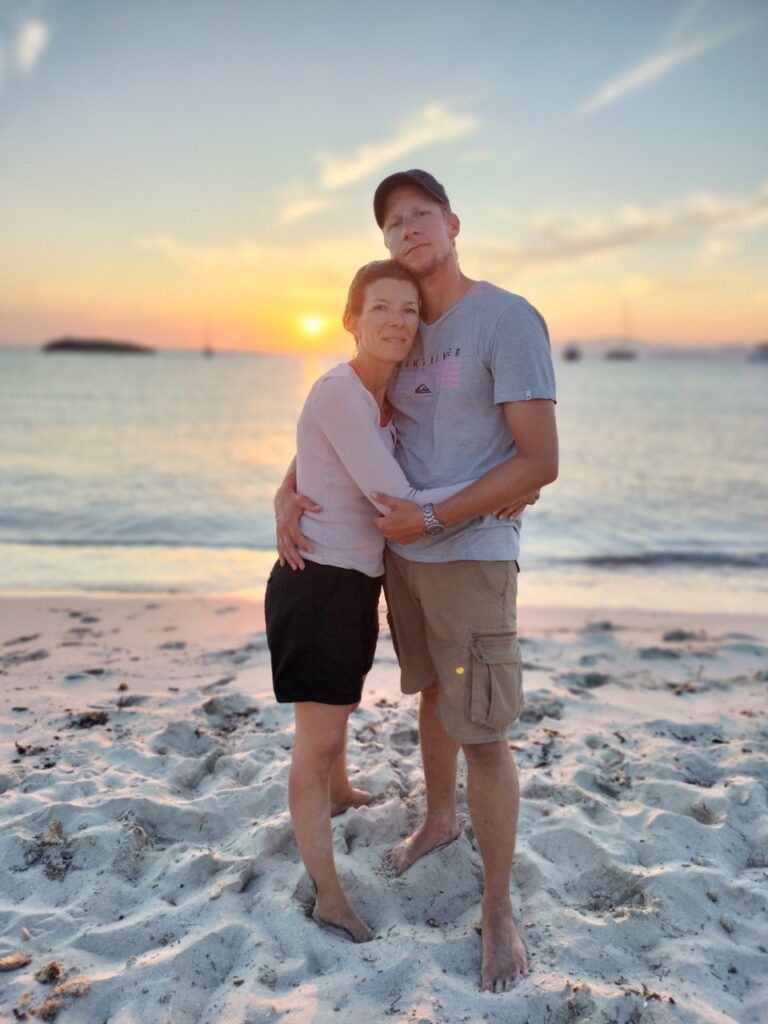 couple debout sur la plage devant couché de soleil Grande