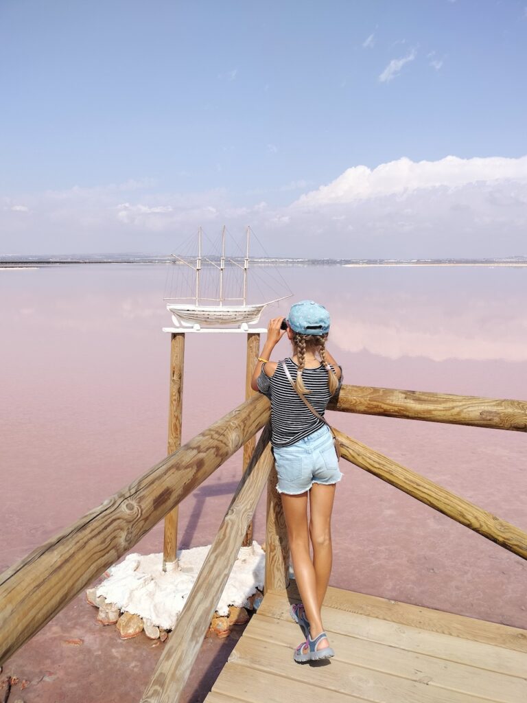 fille devant un bateau de sel dans les salines roses