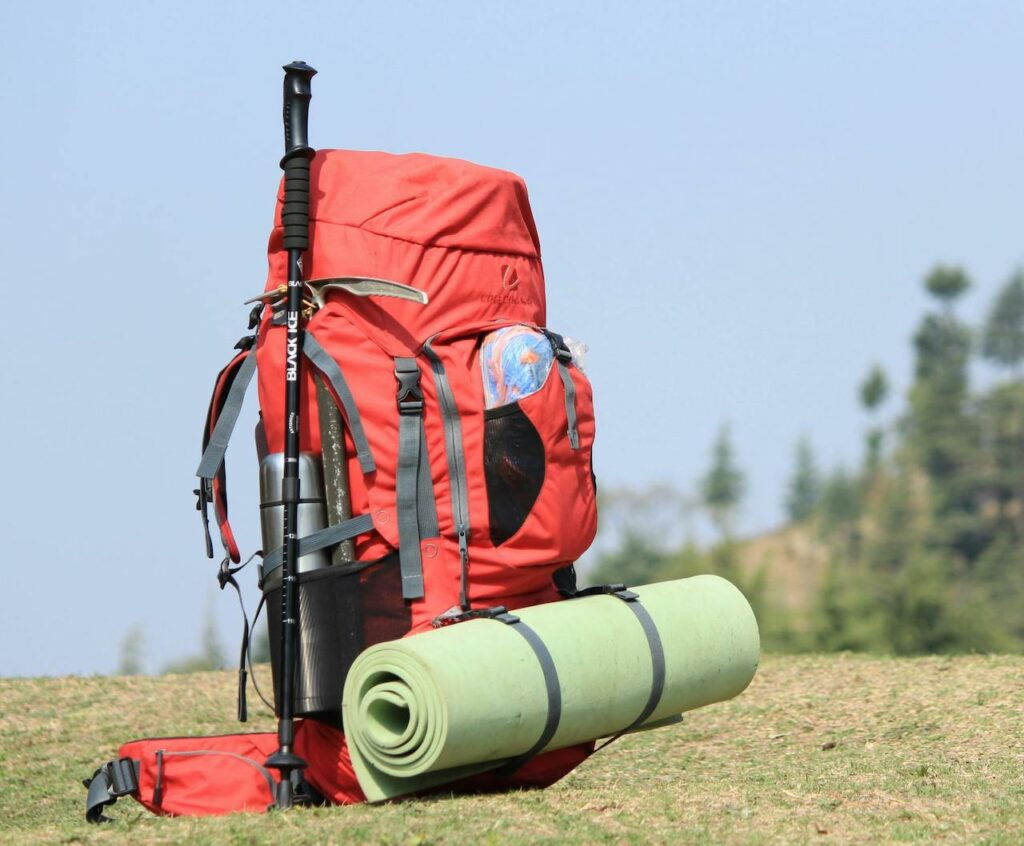sac à dos rouge posé sur l'herbe