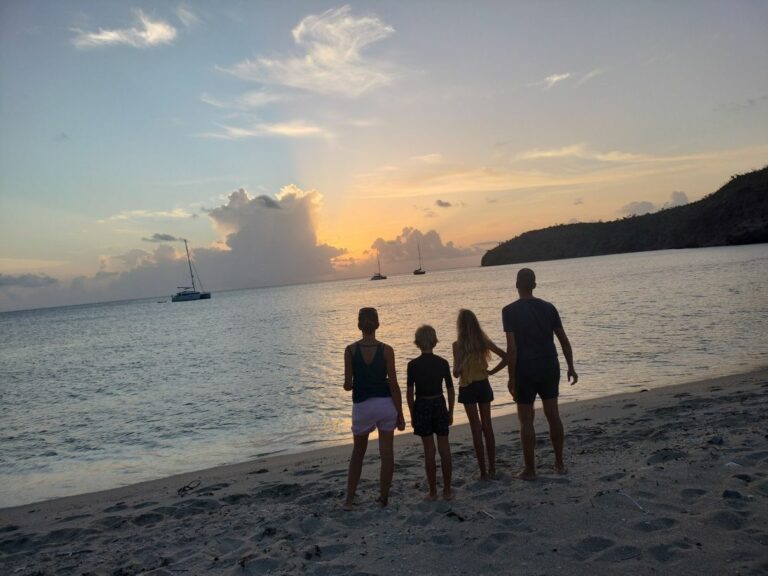 Famille en voyage en bateau regardant un coucher de soleil en mer